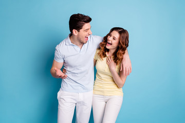 Photo of bonding pair hugging listen humorous story having fun wear casual t-shirts pants isolated blue background