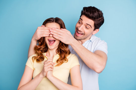 Photo of pair excited bonding buddies hide eyes do not look guess who wear casual t-shirts isolated blue background