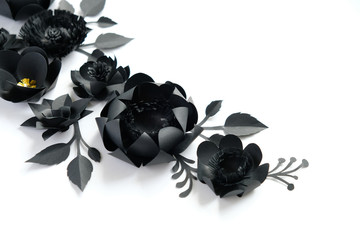 Black paper flowers on white background. Cut from paper.