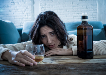 Young, sad, unhappy, helpless woman drinking alcohol. Human emotions, alcoholism and addictions