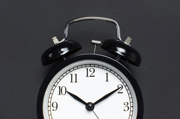 Black retro alarm clock on gray dark background top view Flat lay copy space. Minimalistic...