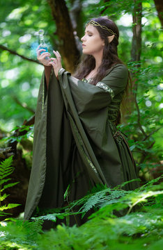 Elf with a bottle of magic potion in the forest