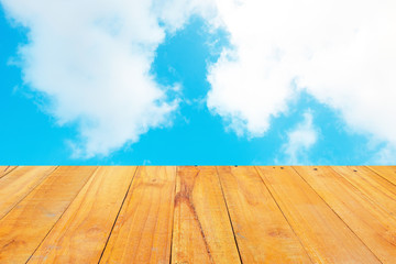 Old Wooden table with blue sky white cloud background.