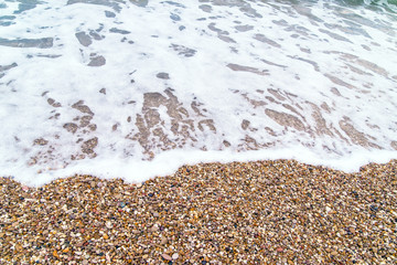 sea pebbles washed by waves on the beach, close up