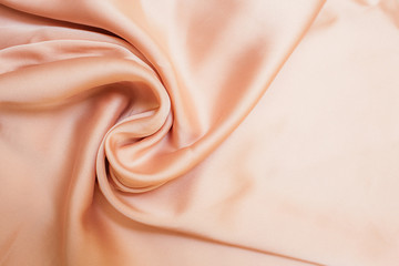 Smooth biege fabric cloth texture with folds and wawes. Close up Abstract background. Biege drapped...