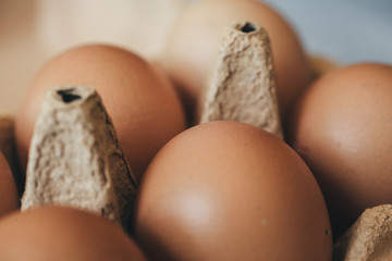 Close up view of fresh eggs in carton box. Healthy eating concept. Macro view of chicken eggs on wooden background.