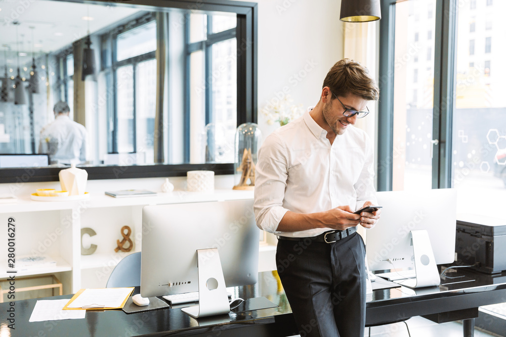 Sticker image of masculine businesslike man holding cellphone while working in office