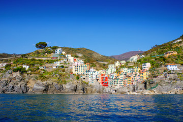 Liguria, Italy coastline of Riviera with colorful houses on sunny warm day. Monterosso al Mare, Vernazza, Corniglia, Manarola and Riomaggiore, Cinque Terre National Park UNESCO World Heritage