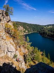 Rear view of women hiker looking at view of forest from Hans rock edge above Lac Blanc at Rocher Hans, France