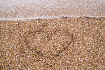 Fototapeta na wymiar heart drawn on the sand, love concept