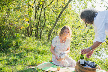 Couple preparing for a picnic by lakeshore, Bavaria Germany