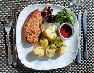 Chopped chicken cutlet, breaded in breadcrumbs from white bread with a side dish of young potatoes
