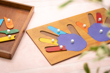 Top view closeup of colorful wooden Montessori sensorial material learning, hands and fingers. Preschool and Kindergarten educational toys, Logical sense, Cognitive skills, Learn Through Play tools.