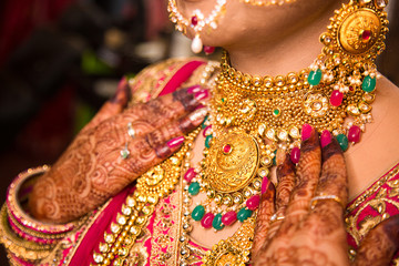 Indian bride wearing heavy jewellery traditional gold necklace, wedding day