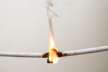 Electrical short circuit. Wiring cable on fire flame