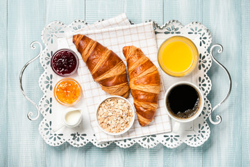 Breakfast with croissants, coffee, jam, orange juice and muesli