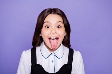 Close-up portrait of her she nice attractive cheerful cheery naughty wavy-haired pre-teen girl showing tongue out having fun isolated over bright vivid shine violet background © deagreez