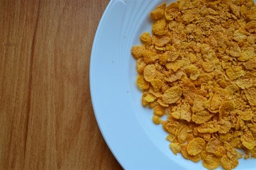  corn flakes on plate at the wooden background 