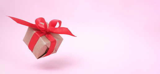 Banner with Gift box red ribbon on pink background. levitation. milimalism. copyspace. Concept sales, shopping, christmas holidays and birthday