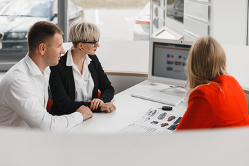 Top view office during a deal between dealer and a  family couple who buying a car