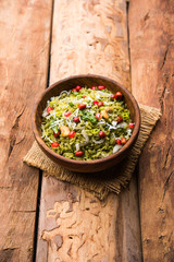 Obraz na płótnie Canvas Hariyali Poha / Green Masala Pohe or flattened rice served in a bowl, selective focus