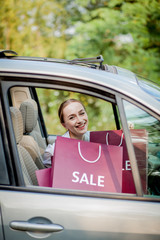 Woman with her shopping bags into the car - shopping concept.