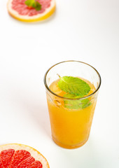 Orange and grapefruit juice in one glass with mint