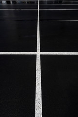 Background: white lines intersecting on black asphalt
