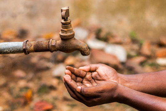 Water Crisis Is A Serious Threat To India And Worldwide,a Man Holding His Hand Under The Tap For Water