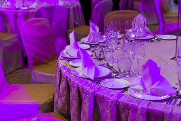 table setting with dishes and napkins at the reception with color lighting