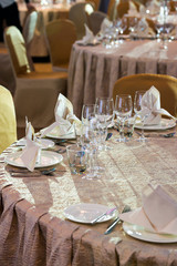 crystal and glass glasses on the served tables for a banquet with color lighting
