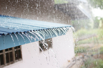Falling rain from the roof on house. © naiauss