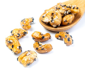 Sesame Coated Cashew Nuts on wooden spoon. Isolated on white background