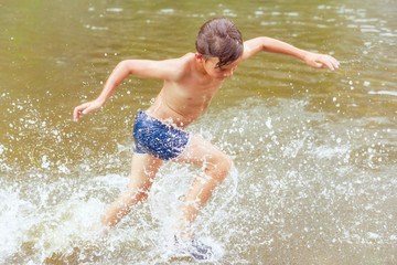 The child runs into the water. Movement splashes and joy. Toning