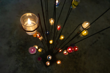 Candles placed in glass, placed on an iron base.