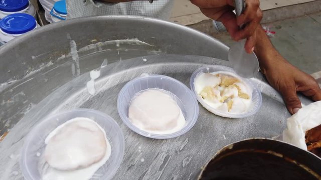 Dahi vada or bhalla is a snack originating from the Indian subcontinent and popular throughout South Asia, prepared by soaking vadas in thick curd or yogurt. 4k 60fps handheld stabilized close-up