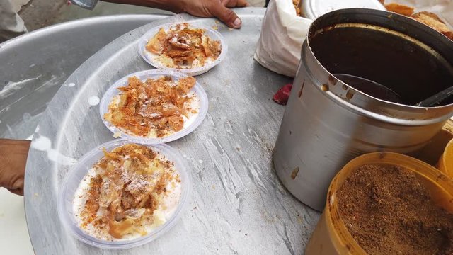 Dahi vada or bhalla is a snack originating from the Indian subcontinent and popular throughout South Asia, prepared by soaking vadas in thick curd or yogurt. 4k 60fps handheld stabilized close-up