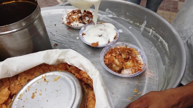 Dahi vada or bhalla is a snack originating from the Indian subcontinent and popular throughout South Asia, prepared by soaking vadas in thick curd or yogurt. 4k 60fps handheld stabilized close-up