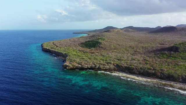 Aerial view of coast of Curaçao in the Caribbean Sea with turquoise water, cliff, beach and beautiful coral reef around the Sta. Martha Bay