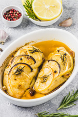 Lemon rosemary chicken breasts in a baking dish. Selective focus, space for text.