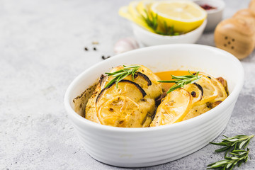 Lemon rosemary chicken breasts in a baking dish. Selective focus, space for text.