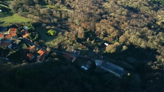 Aerial: Small tipical Karst village in middle of the forest beside rocky cliffs. Filmed while flying with drone in Karst region in Slovenian seaside.