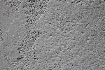 Texture of a roughly plastered gray stonewall, background with copy space