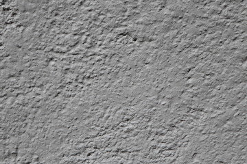 Texture of an unevenly plastered grey stonewall, background with copy space