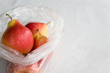 The concept of environmental protection, the use of plastic. Fresh natural fruit in a plastic bag. Top view, copy space, close-up.