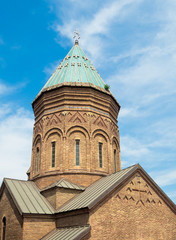 Fototapeta na wymiar Armenian Saint George's Church in Tbilisi against blue sky with clouds
