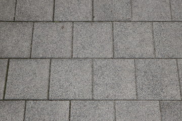 Fototapeta premium Abstract background with paving slabs on the gray sidewalk, copy space