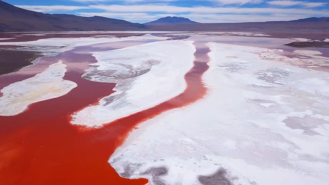 Aerial view of the Laguna Colorada - lake with salty orange water and salt crust on its surface. Bolivia, Altiplano