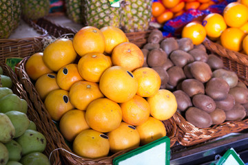 pile of juicy oranges in wicker baskets on market counter