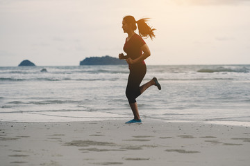 Runners. Young people running on beach. Athletic attractive people jogging on beach enjoying the sun exercising their healthy lifestyle.